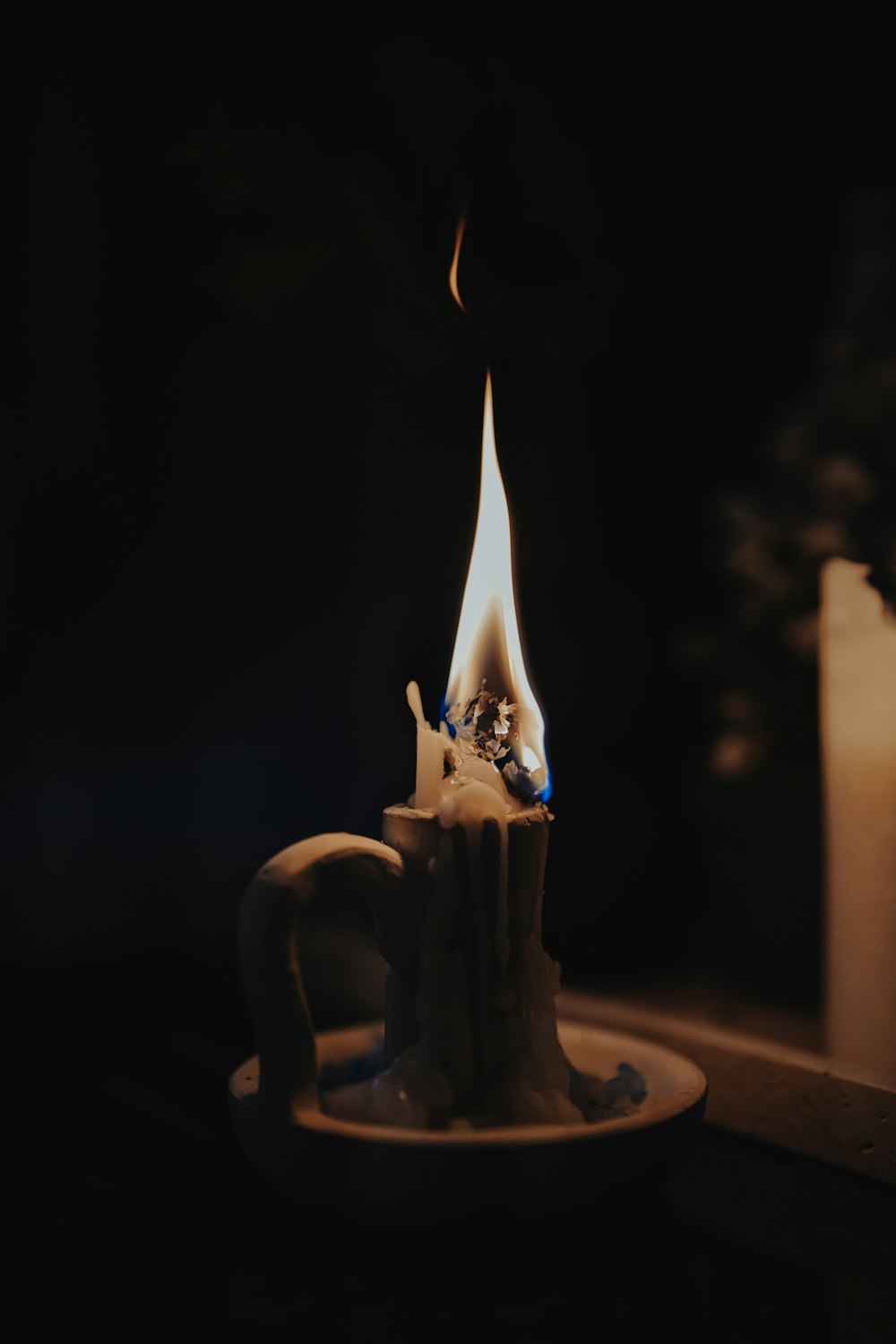 a lit candle sitting on top of a white plate