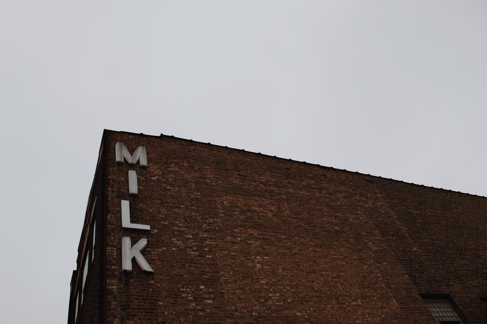 un edificio in mattoni con un cartello che dice latte su di esso