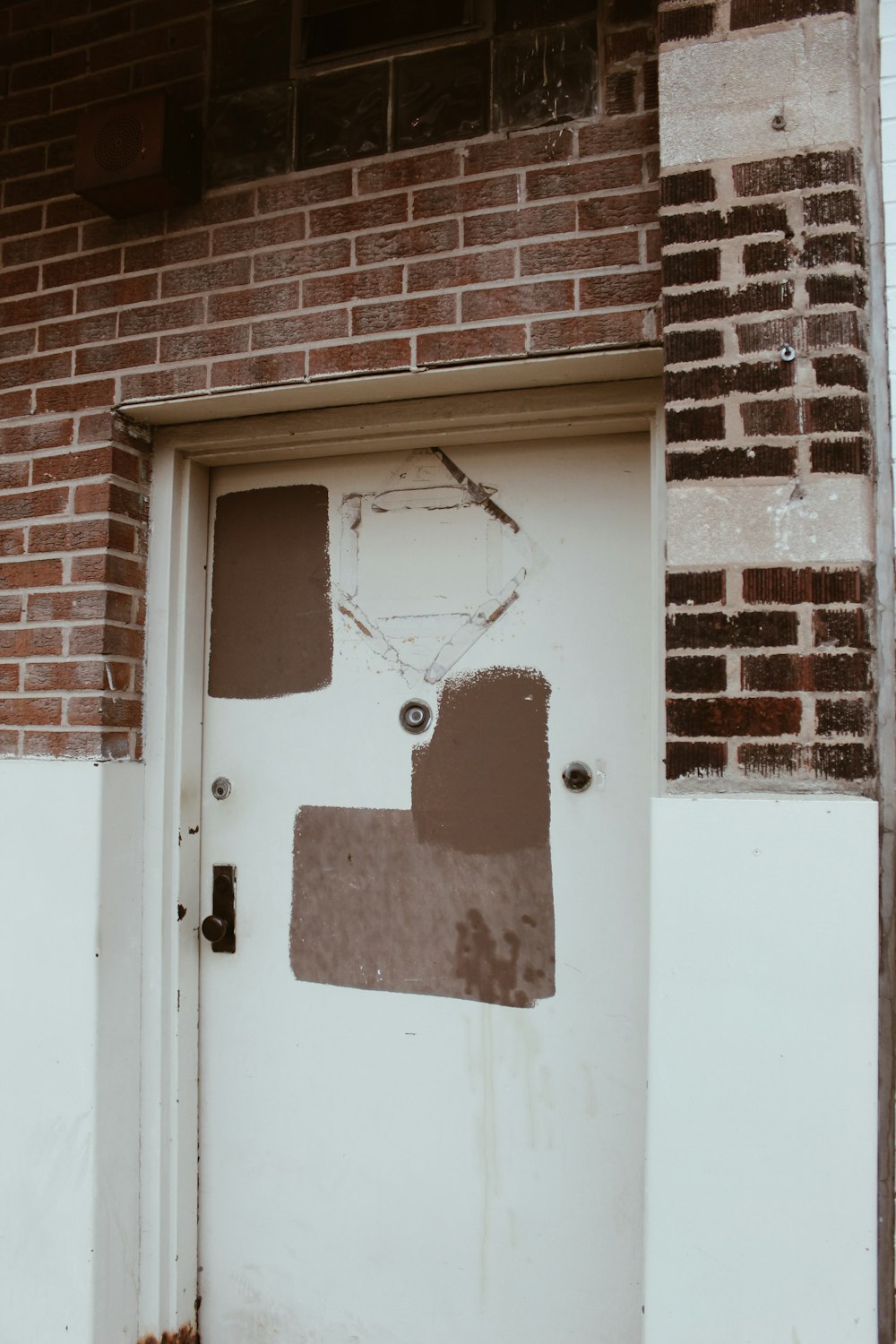 a white door with a brick wall behind it