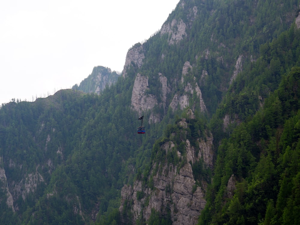 a paraglider is flying over a mountain side