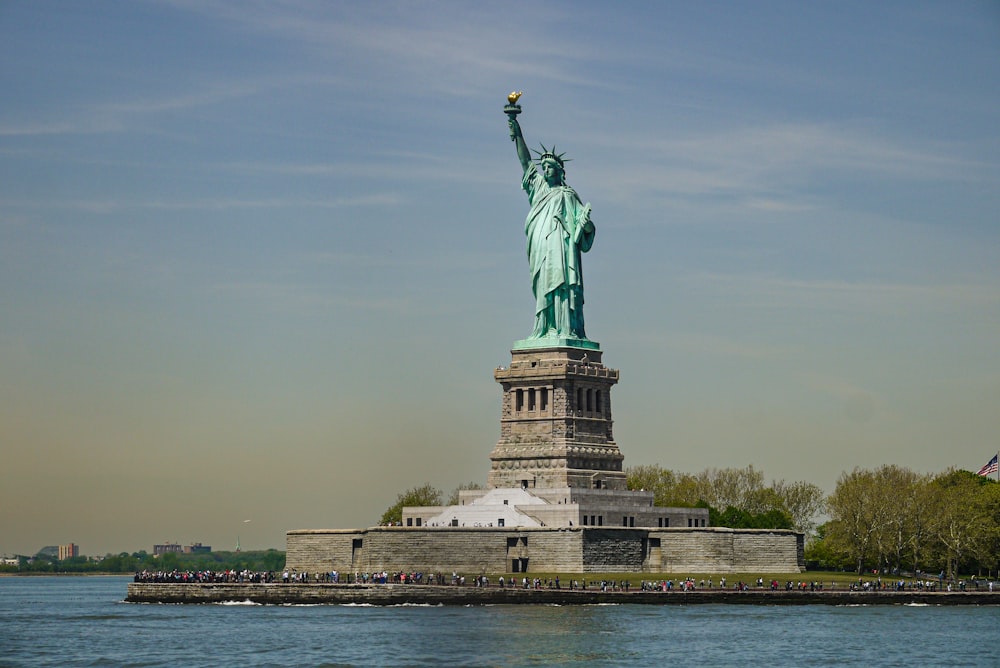 the statue of liberty stands in the middle of the water