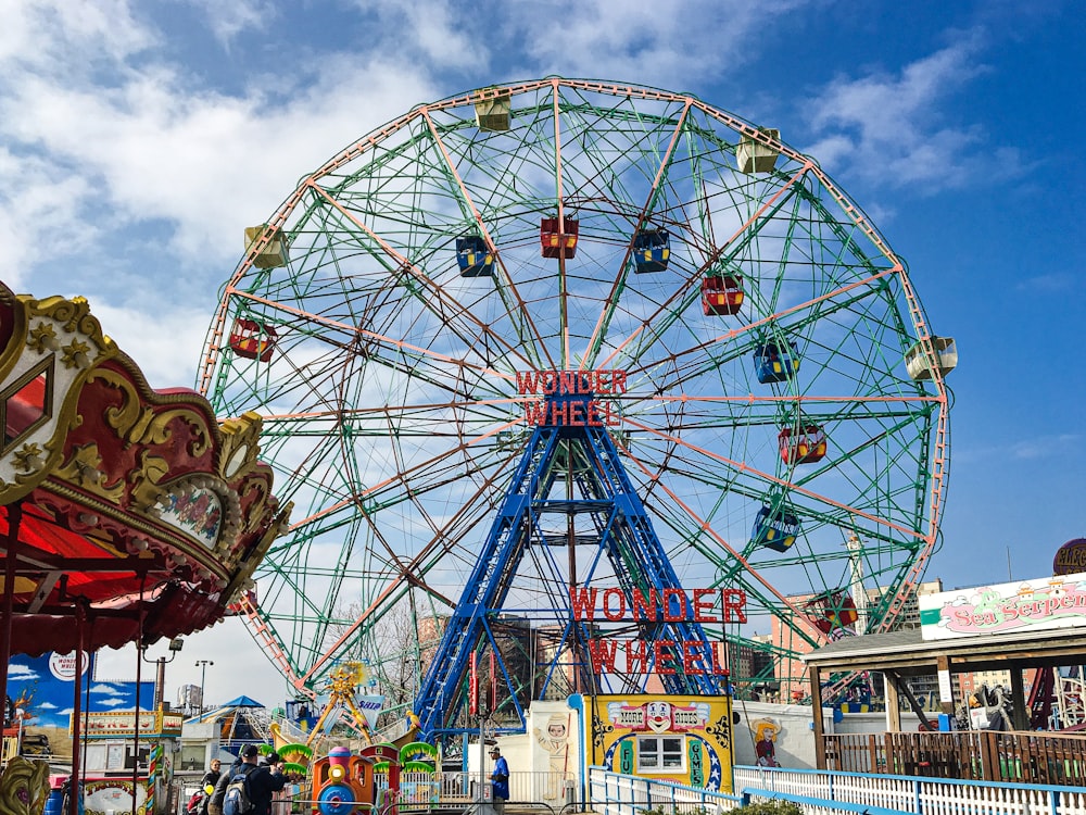 a large ferris wheel sitting next to a carnival ride