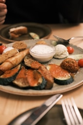 a plate of food on a table with a knife and fork
