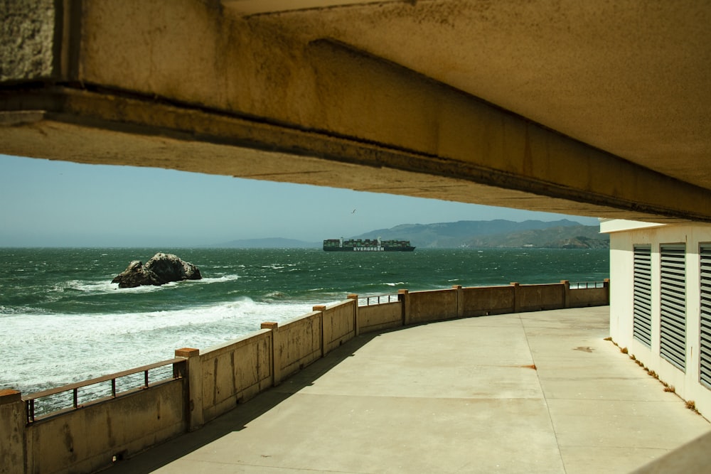 a view of the ocean from under a bridge
