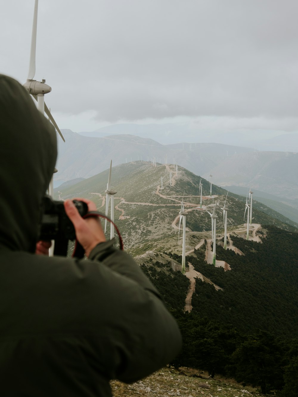 a person taking a picture of a wind farm