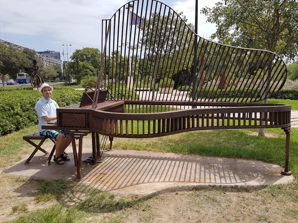 a man sitting on a bench in a park