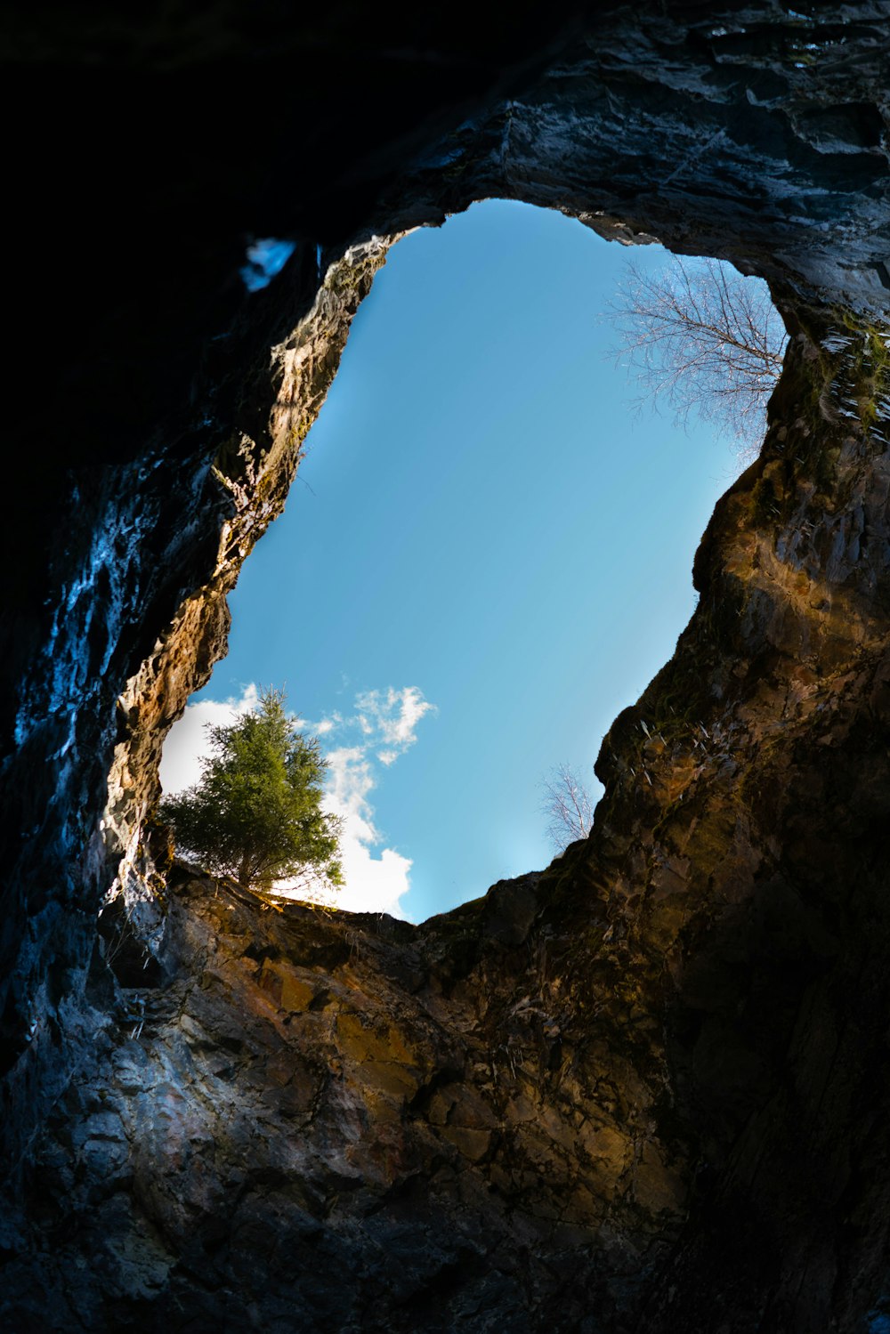 a view of the sky from inside a cave