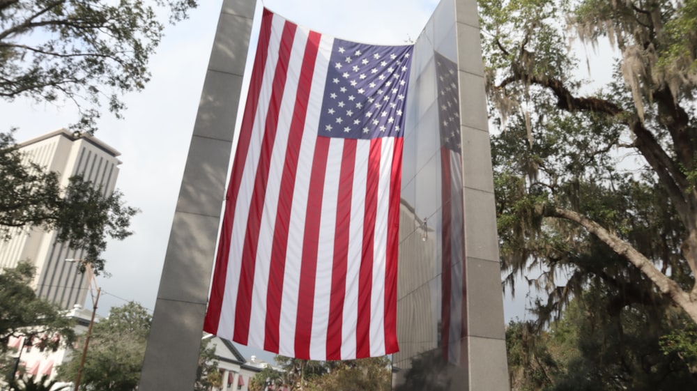 a large american flag hanging from the side of a monument