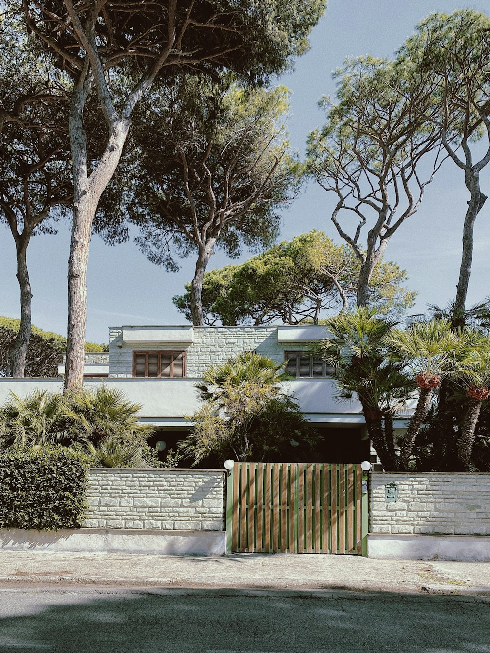 a house with trees and a fence in front of it