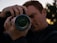 A focused photographer adjusting his camera lens during a vibrant outdoor shoot.