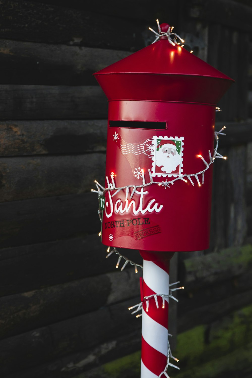 a red mailbox decorated with christmas lights