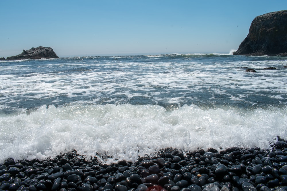 a rocky beach with waves coming in to shore