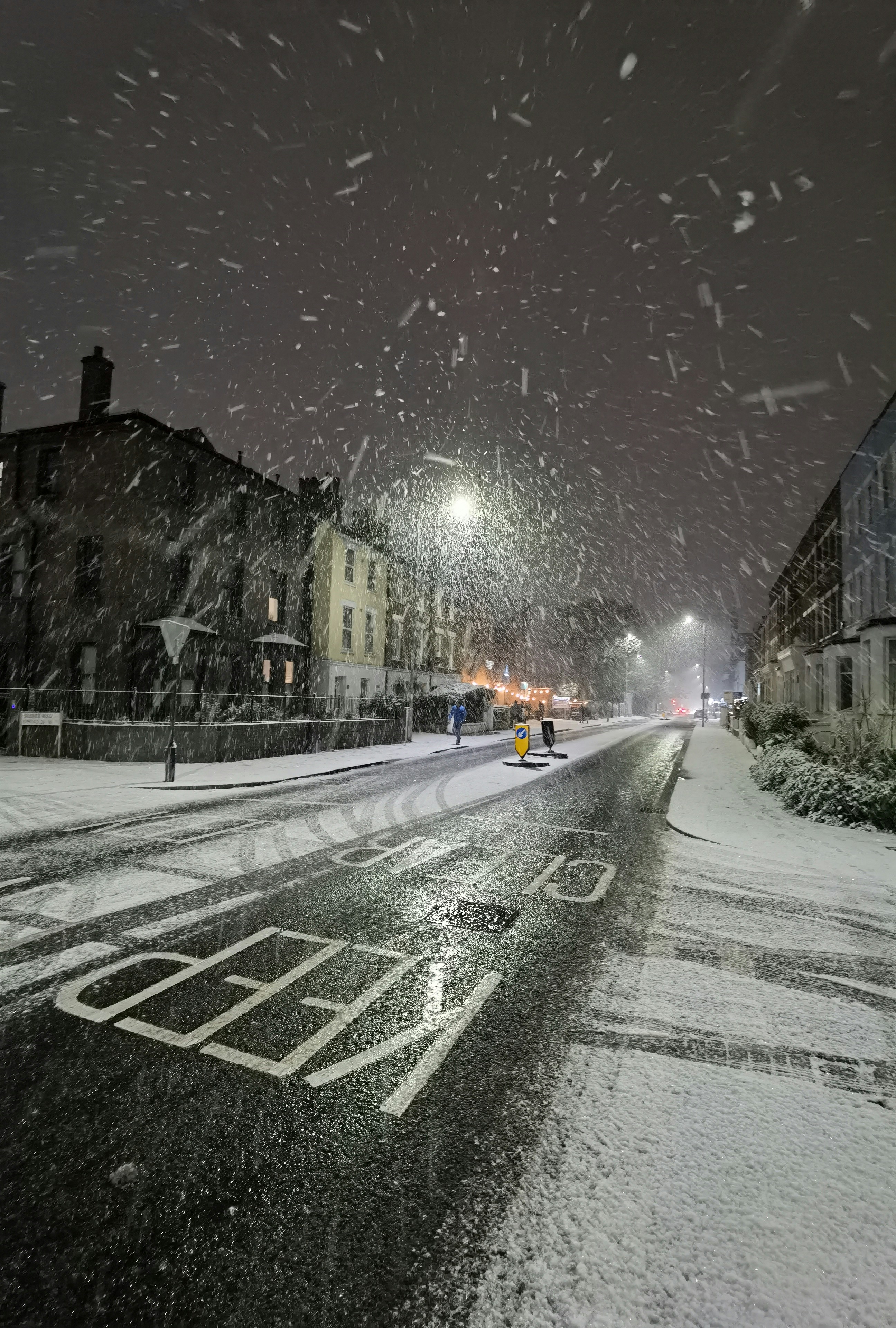 a snowy night in a small town with a crosswalk