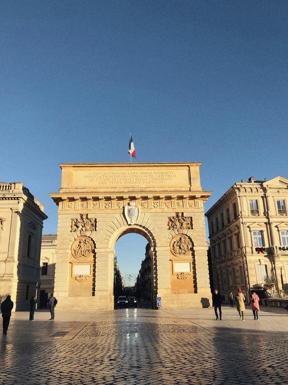 a large stone arch with a flag on top of it