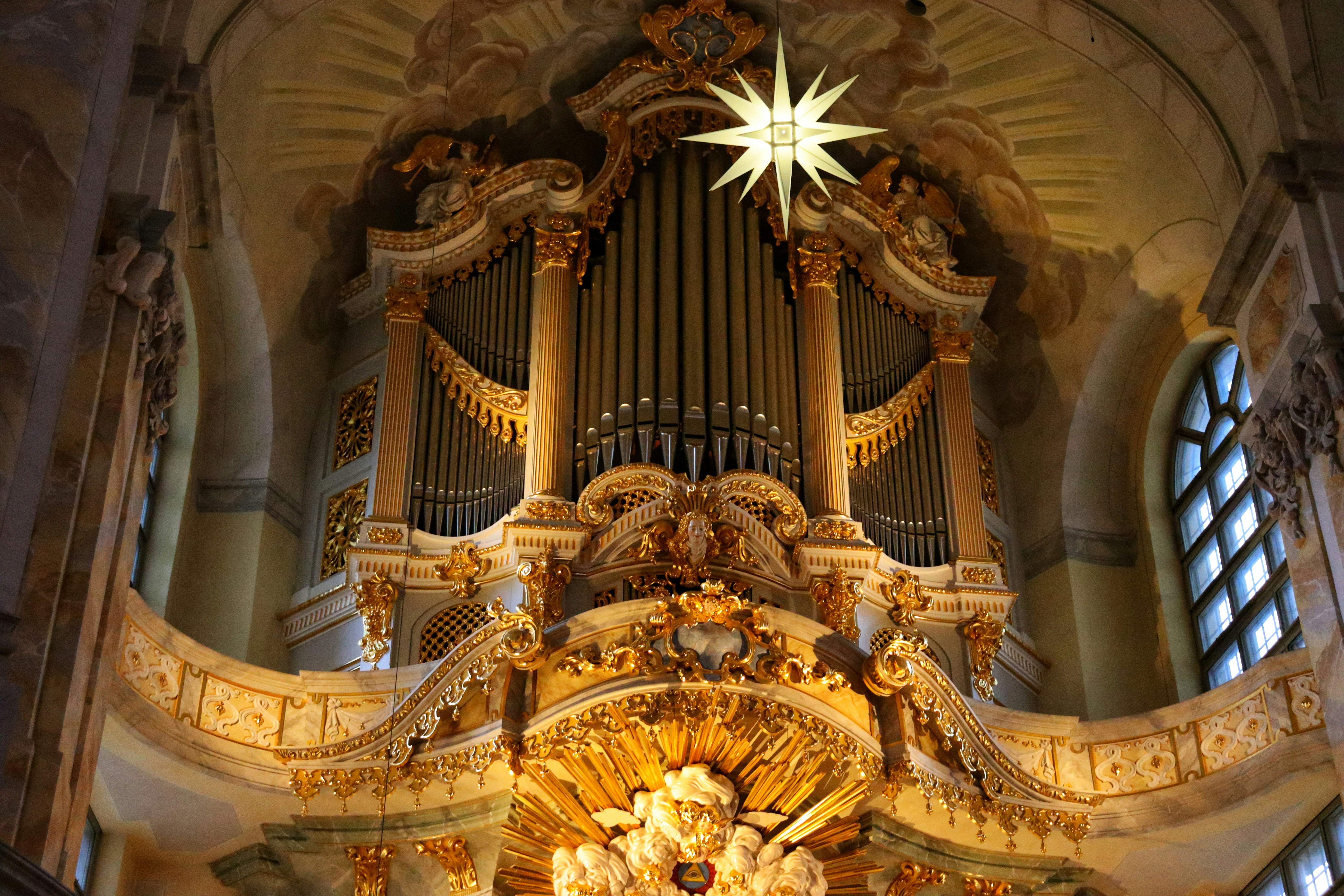 a large pipe organ in a church with a star above it