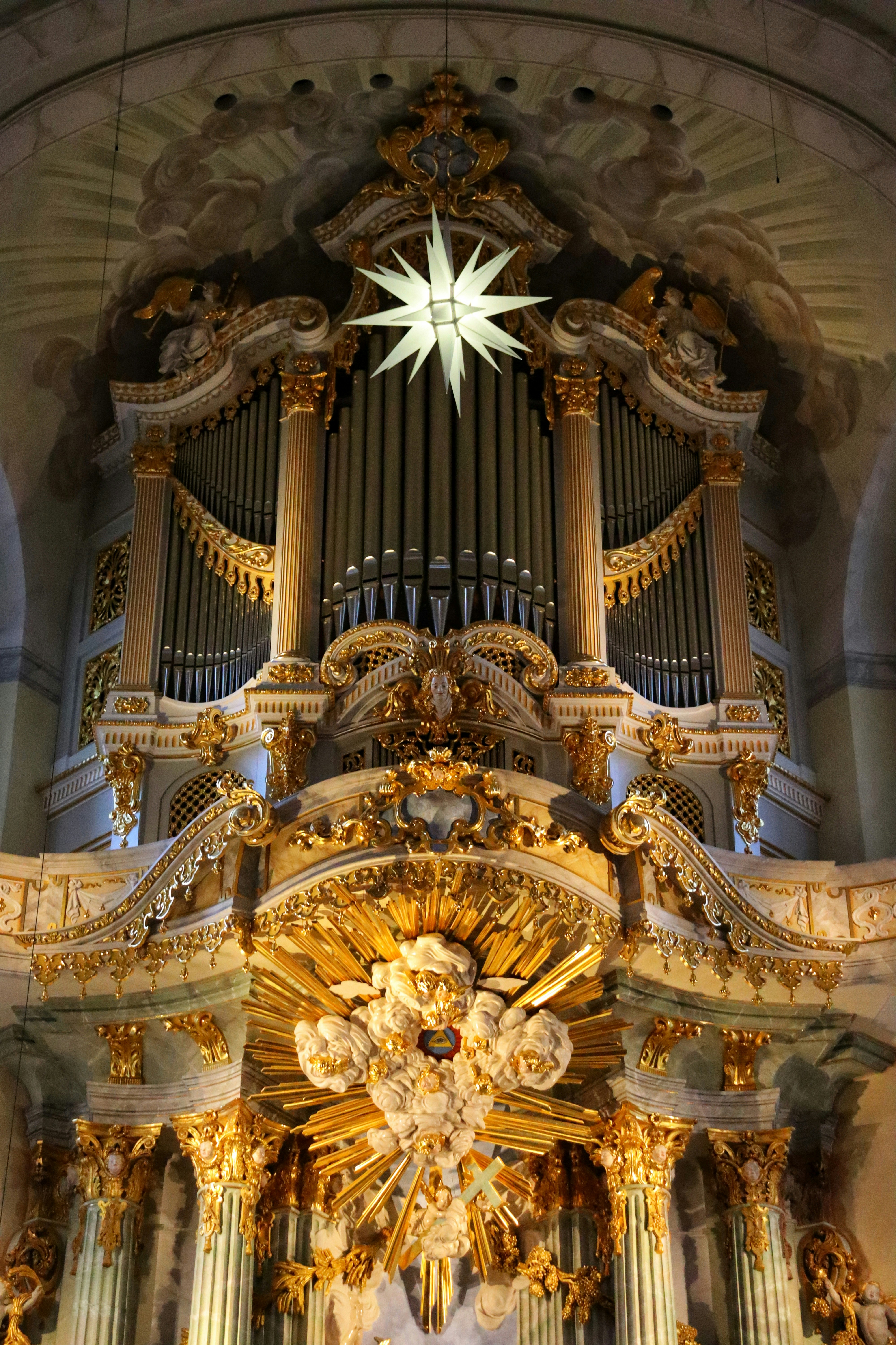 a large pipe organ in a church with a star above it