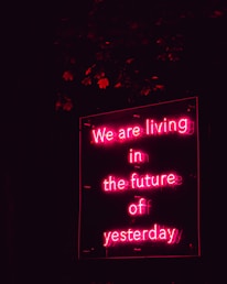 a neon sign that says we are living in the future of yesterday