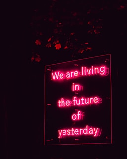 a neon sign that says we are living in the future of yesterday