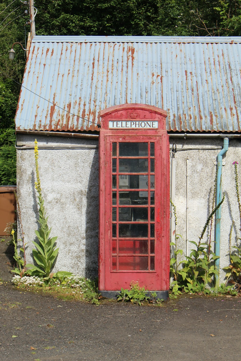 a red phone booth sitting next to a building