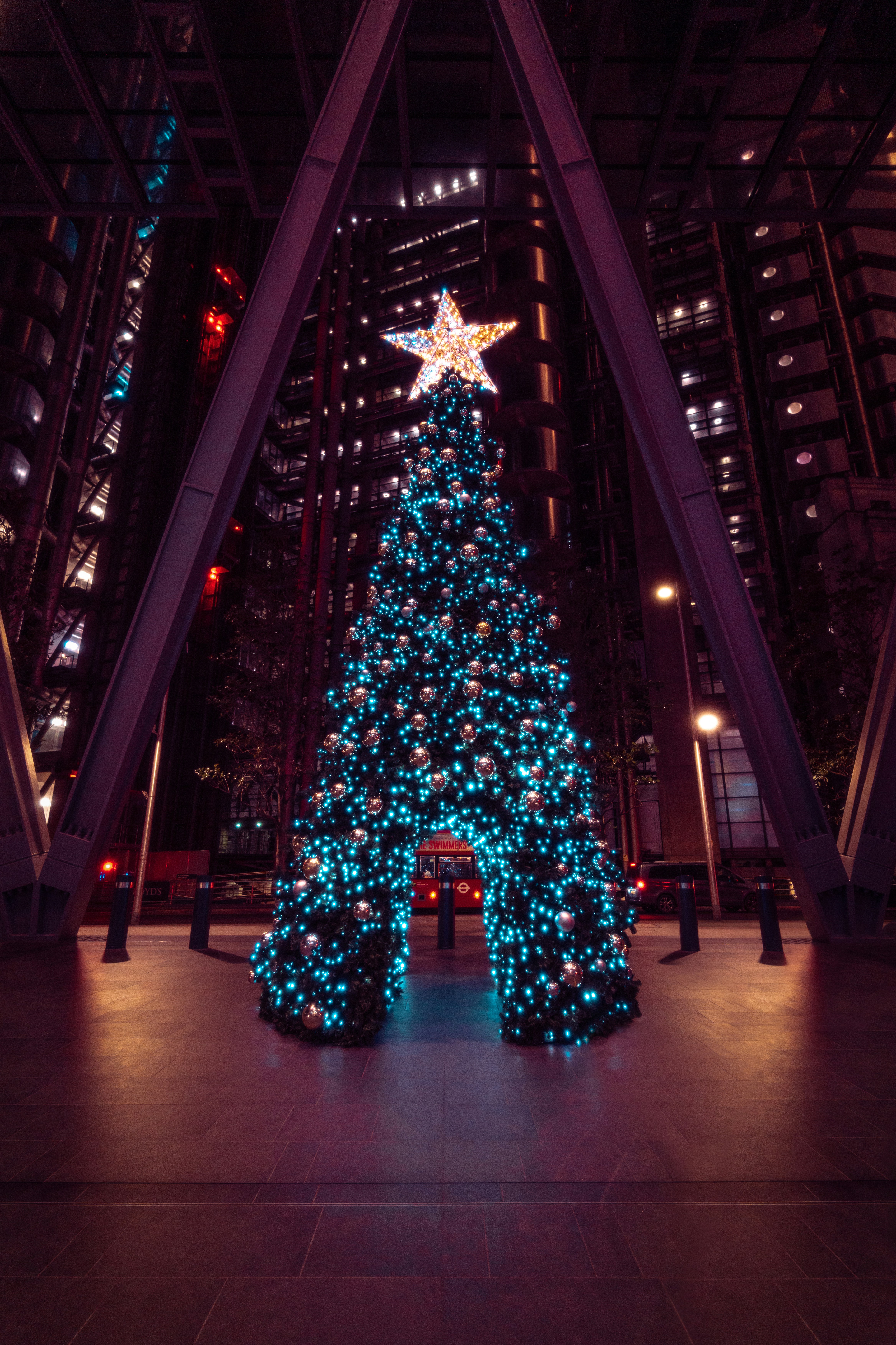 a lit christmas tree in a large building