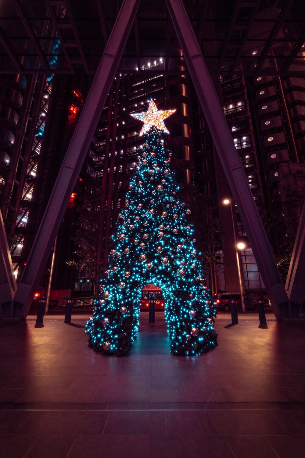 a lit christmas tree in a large building