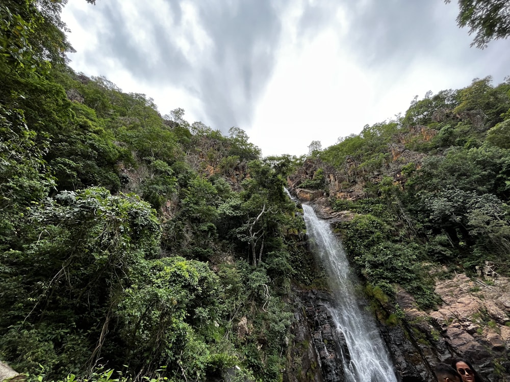 Ein Mann steht vor einem Wasserfall