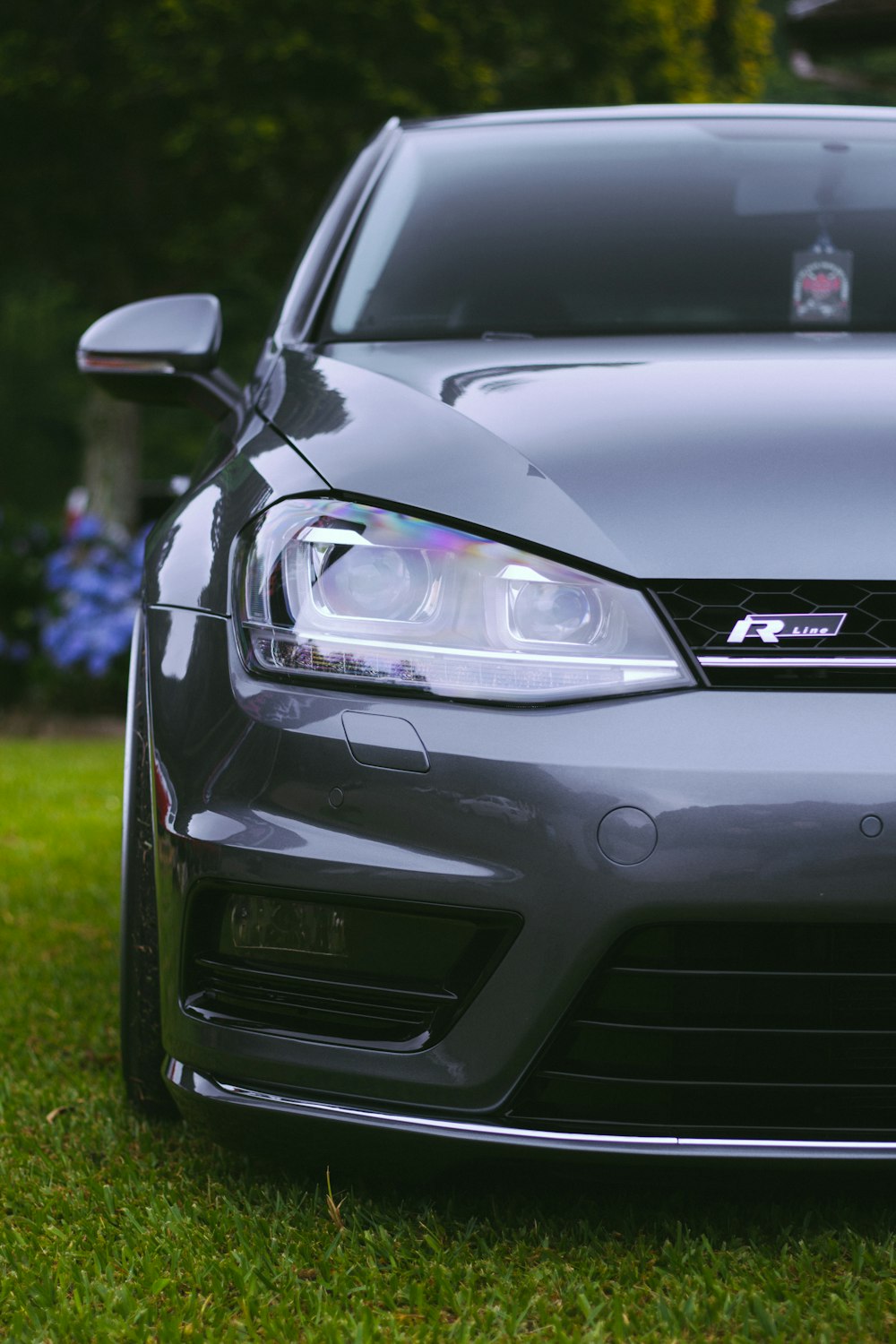 a grey car parked on top of a lush green field