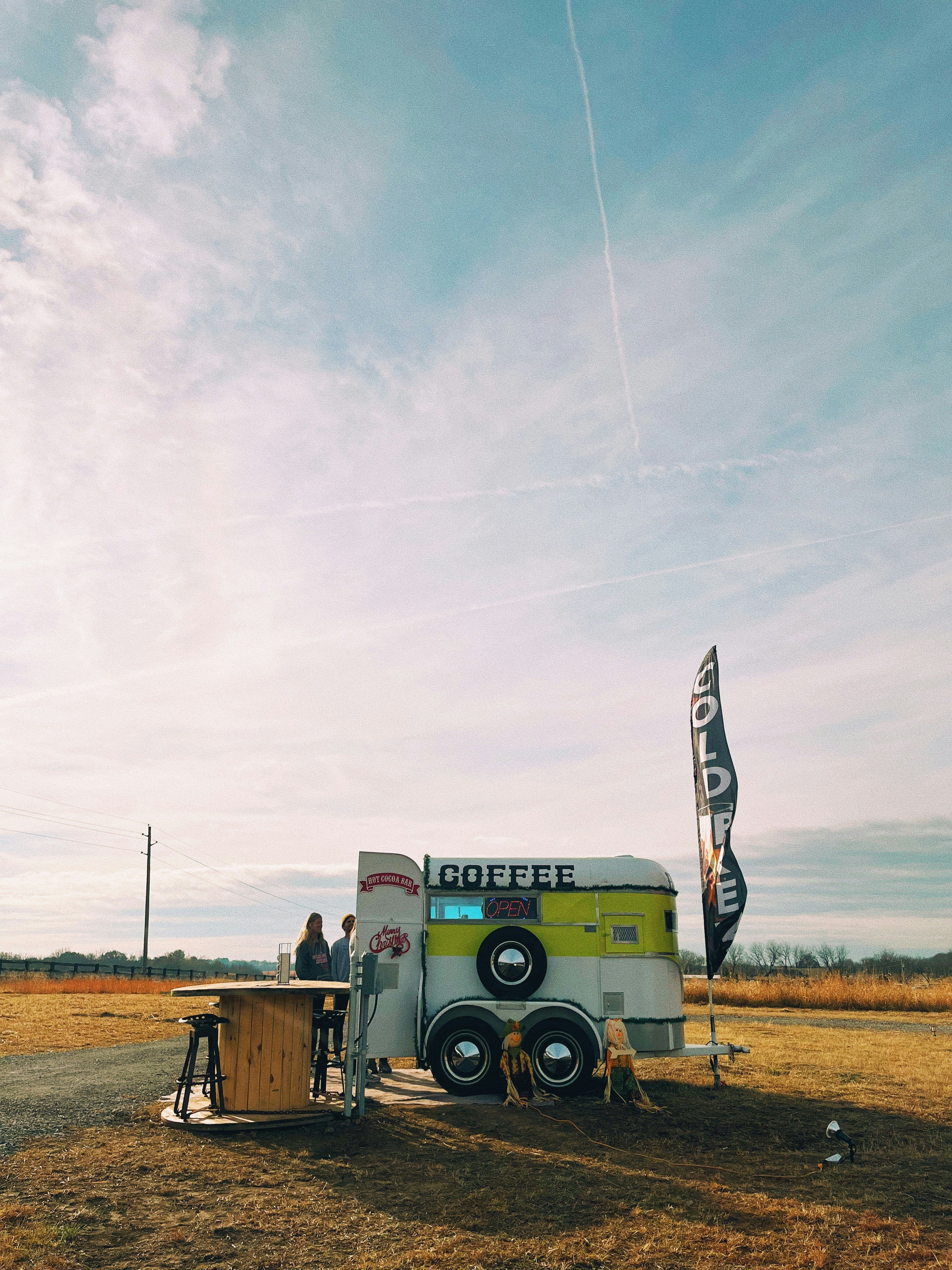 A stylish mobile coffee cart with a barista making coffee.