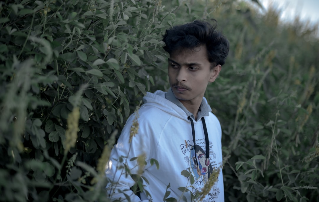 a man standing in a field of tall grass,