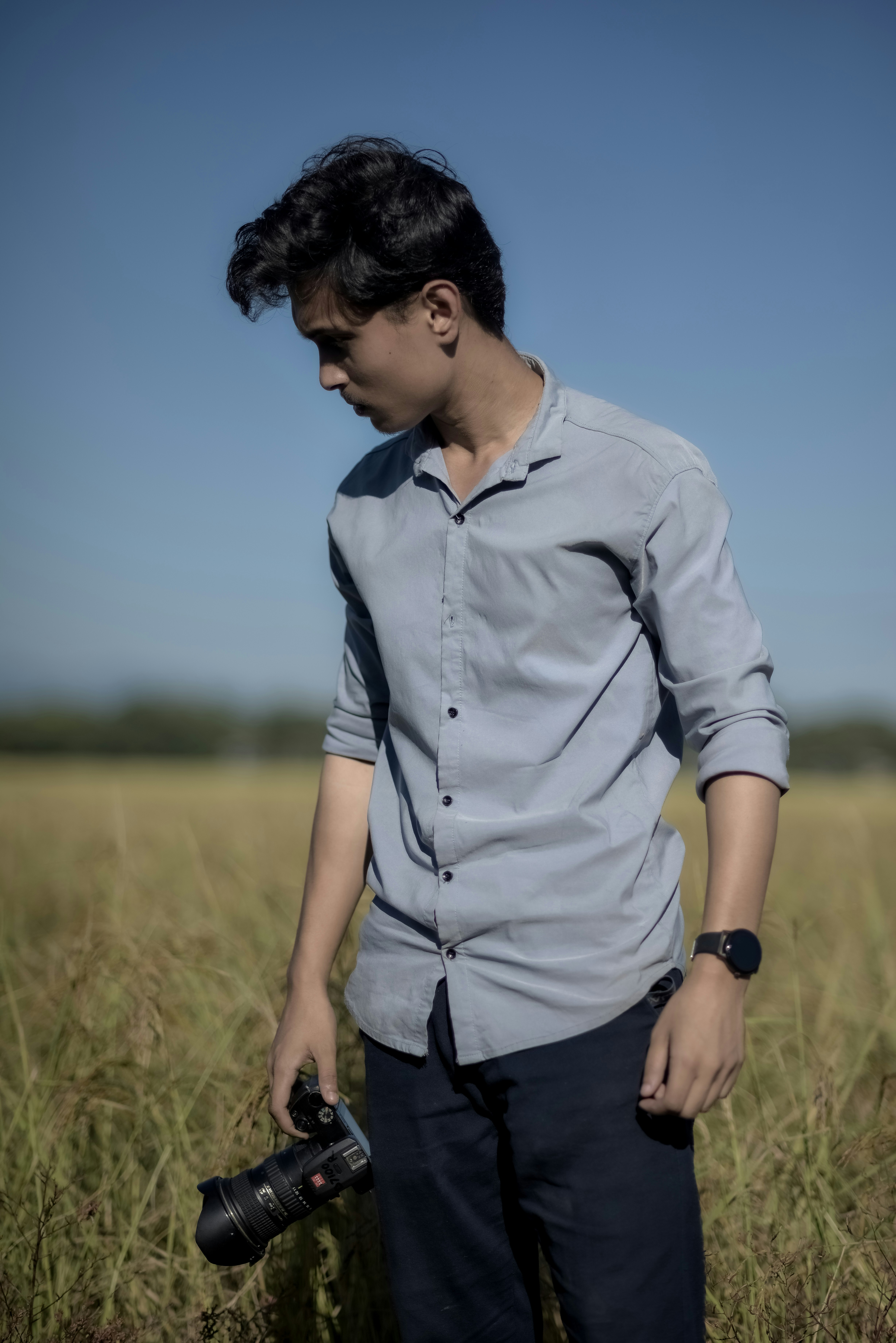 a man standing in a field holding a camera