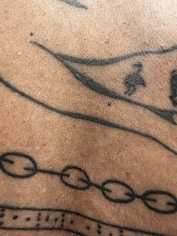 Close-up of fresh tattoo with red and black ink on skin.