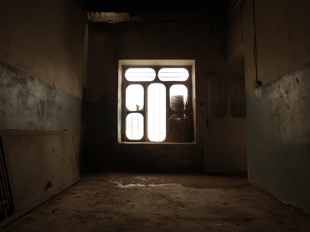 a dark room with a window and a dirty floor