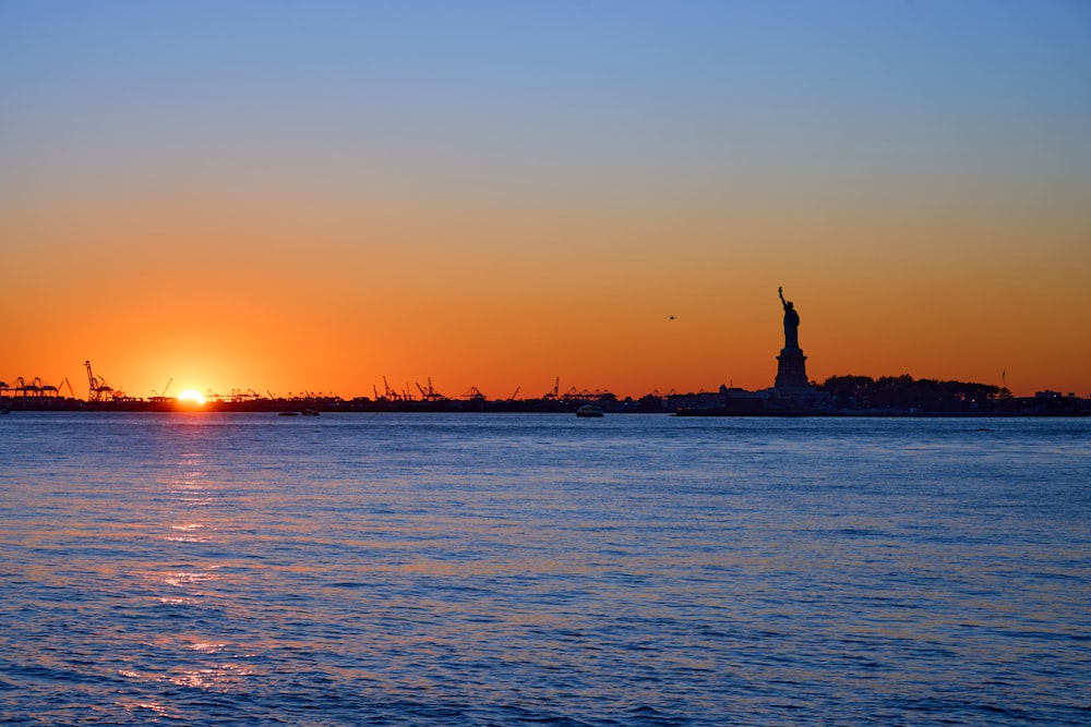 the sun is setting over a body of water