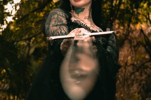 a woman in a black dress holding a knife