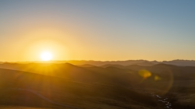 A serene landscape photo showcasing a golden hour glow over rolling hills, emphasizing natural light and simplicity.