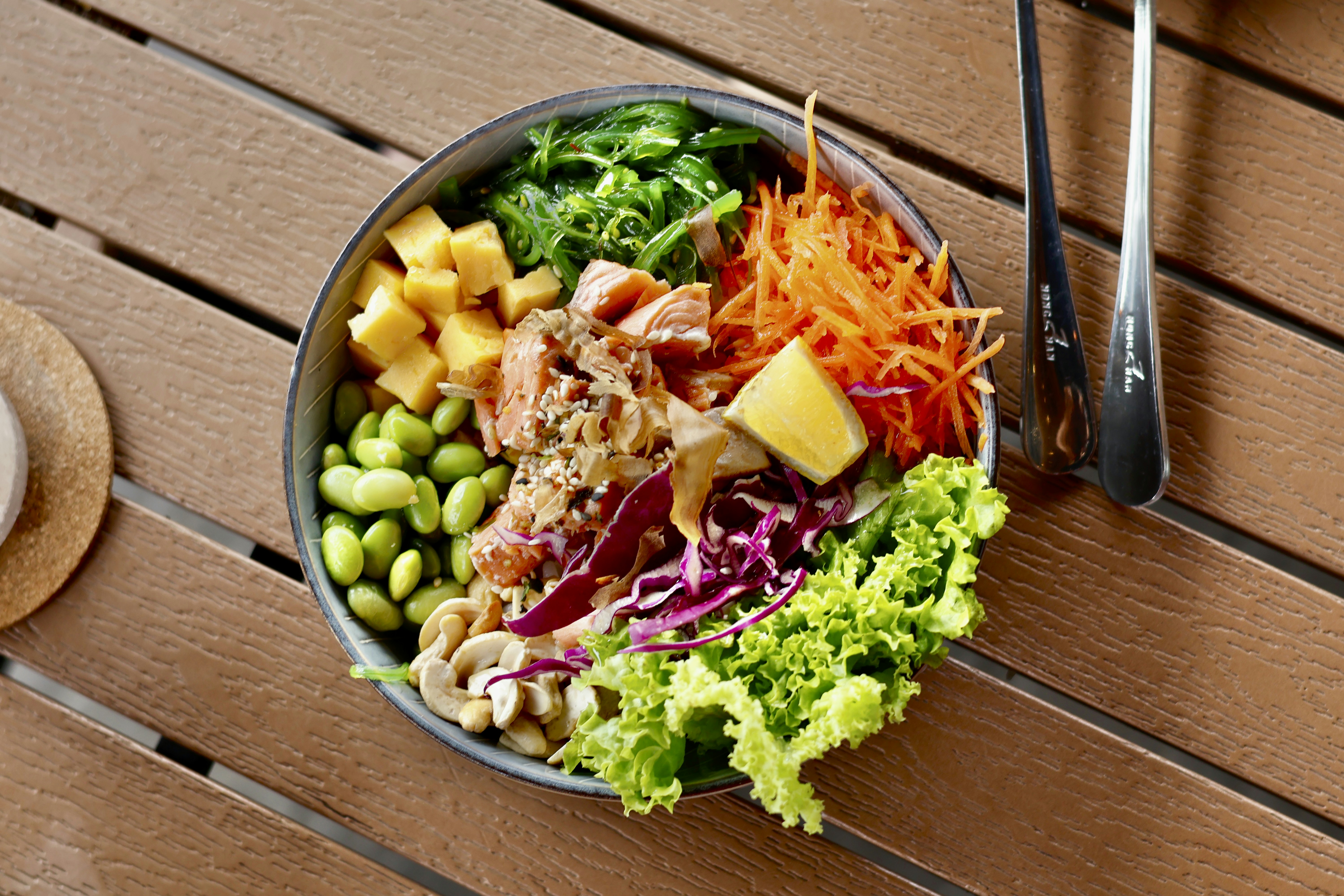 Salmon poke bowl with edamame, seaweed, and colorful vegetables — omega-3 rich postpartum meal.