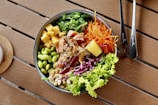 a bowl of food sitting on a wooden table