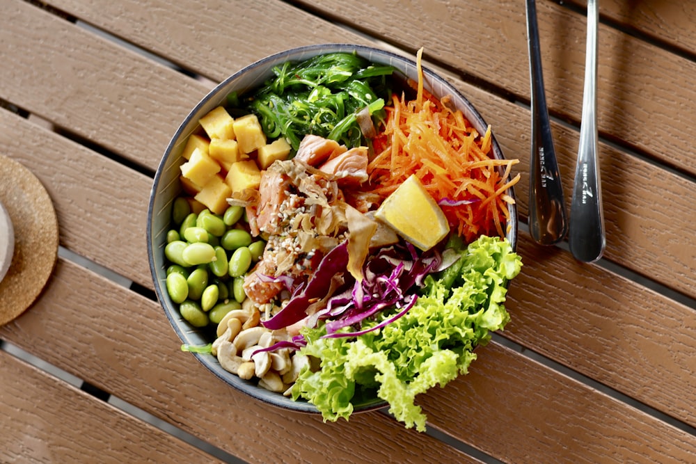 a bowl of food sitting on a wooden table