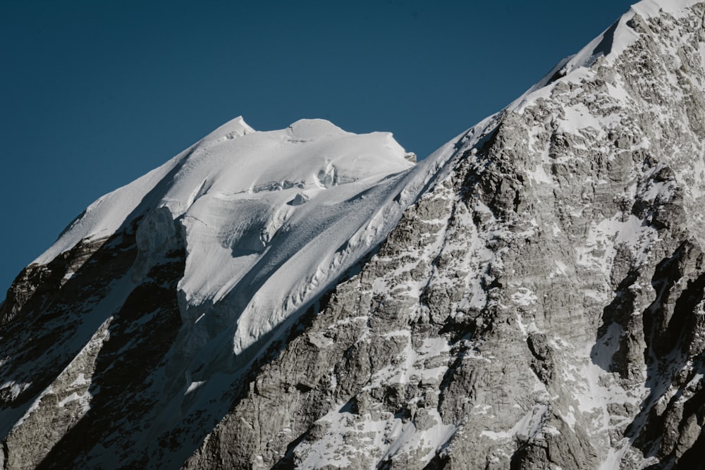 Una montaña cubierta de nieve con un cielo azul en el fondo