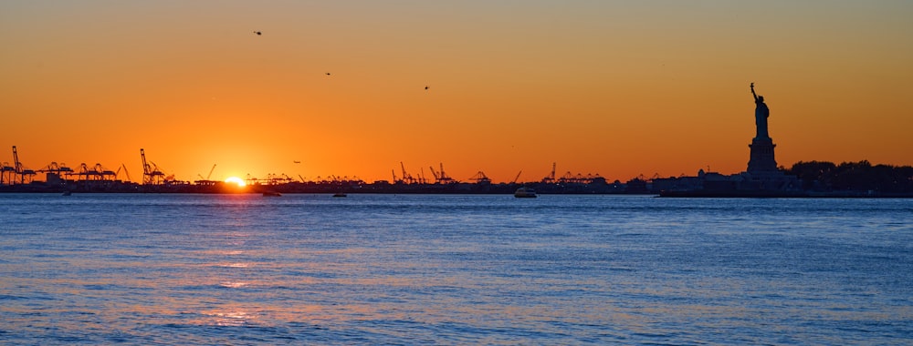 a large body of water with a sunset in the background