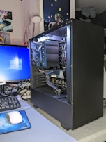 Technician testing a desktop computer with diagnostic equipment.