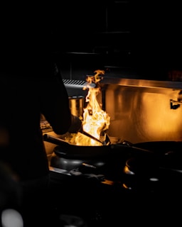 a person cooking food on a grill in the dark