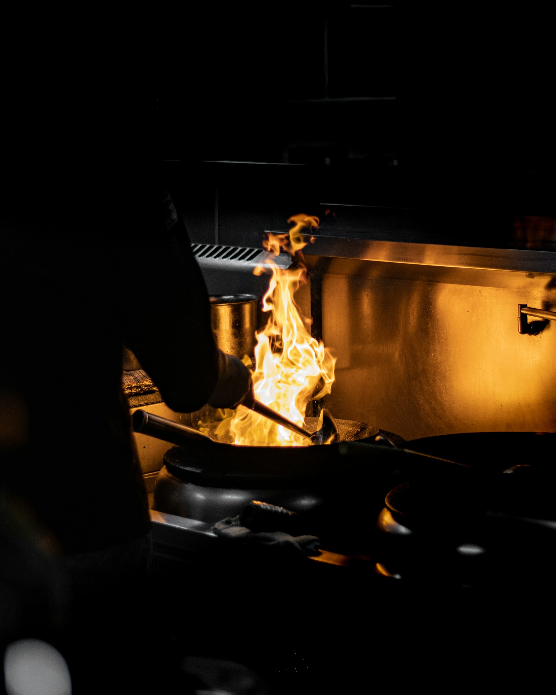 a person cooking food on a grill in the dark