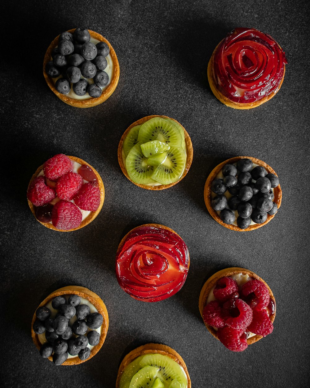 a group of fruit tarts sitting on top of a table