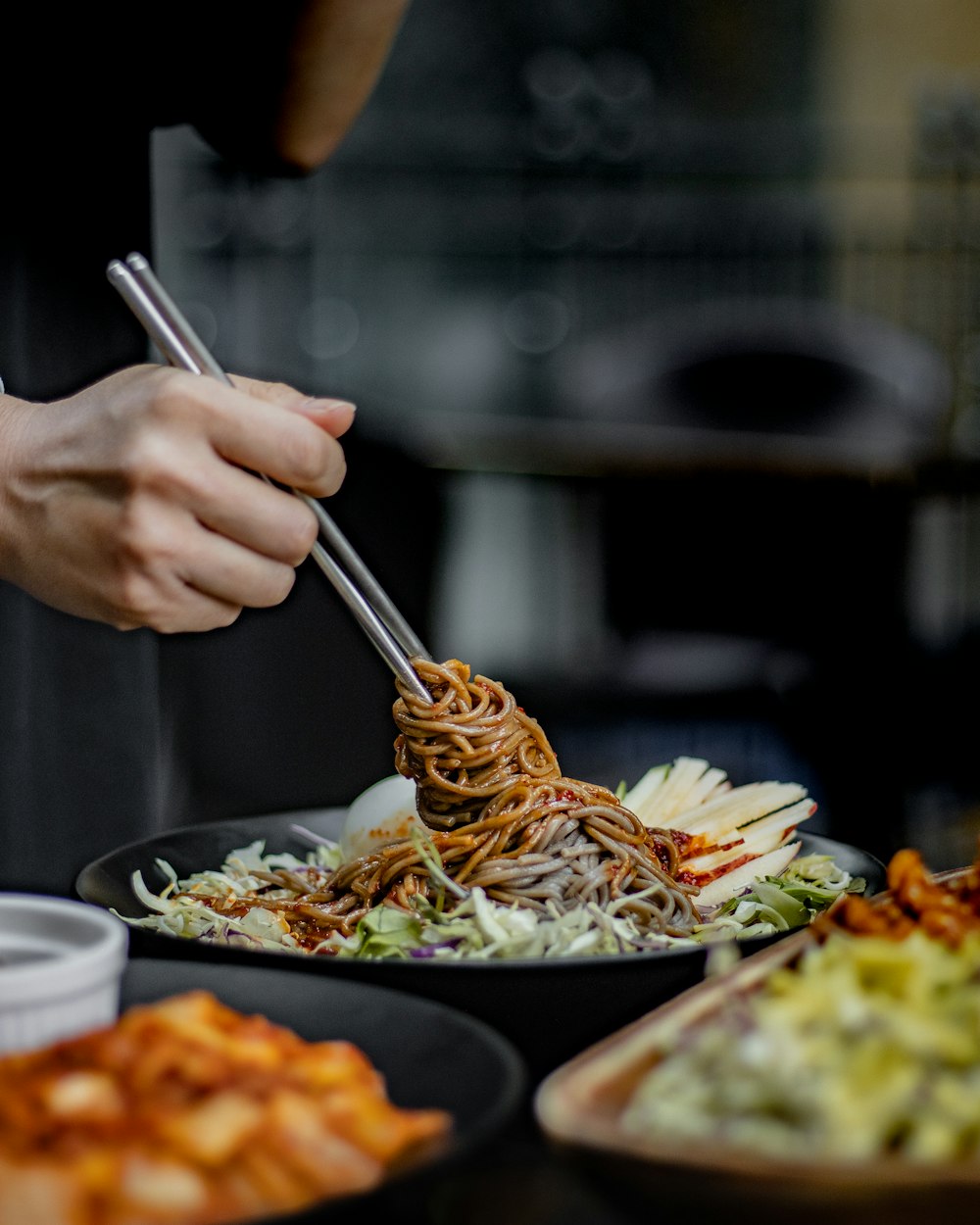 a person holding chopsticks over a plate of food