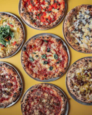a group of six pizzas sitting on top of a table
