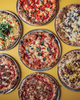 a group of six pizzas sitting on top of a table