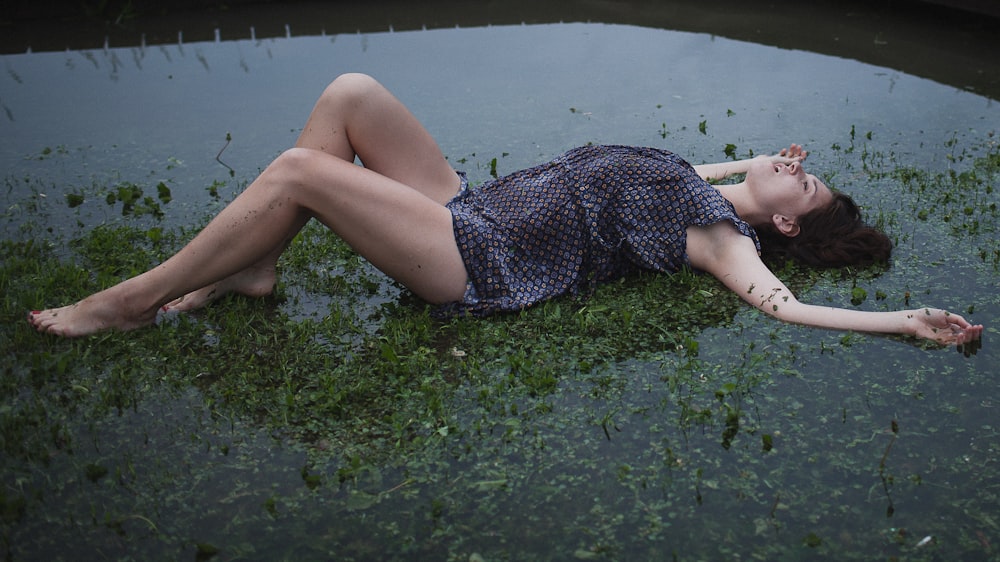 a woman laying on the ground in the water