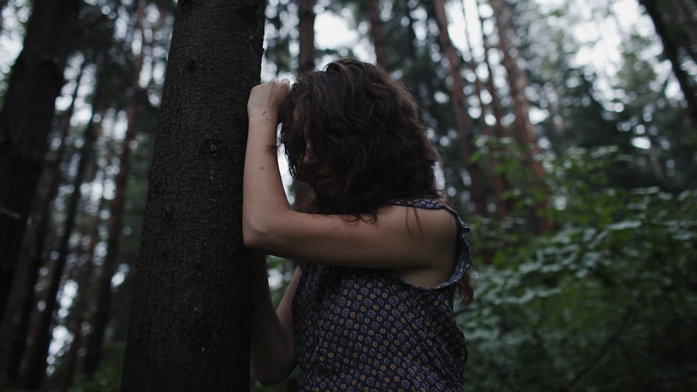 a woman standing in the middle of a forest