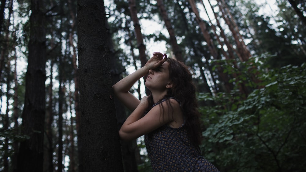 a woman standing in the middle of a forest